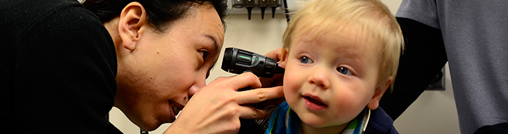 Medical professional looking into toddlers ear with tool