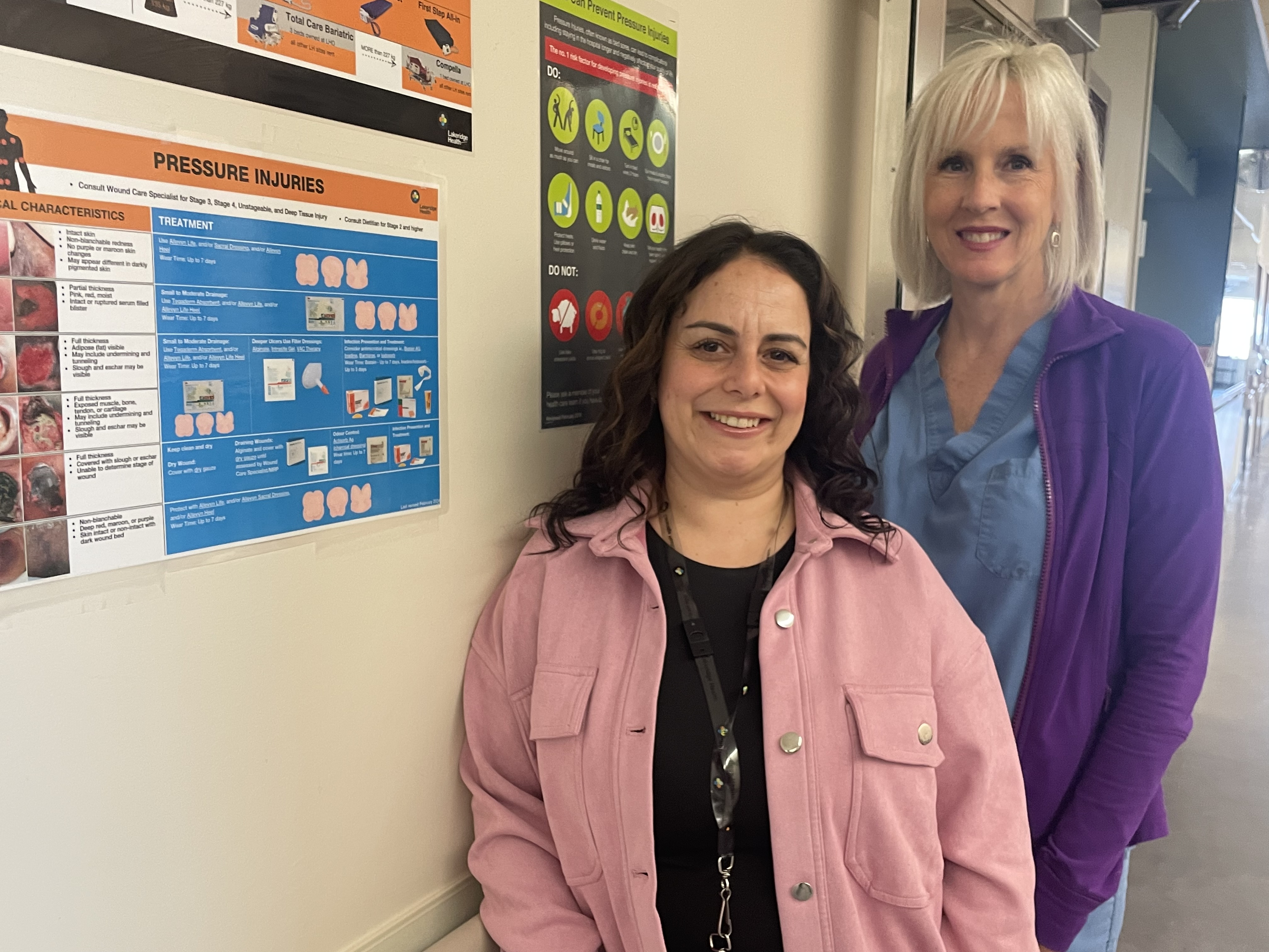 Taleen and Lauren standing beside a Wound Care Assessment sign on C7.